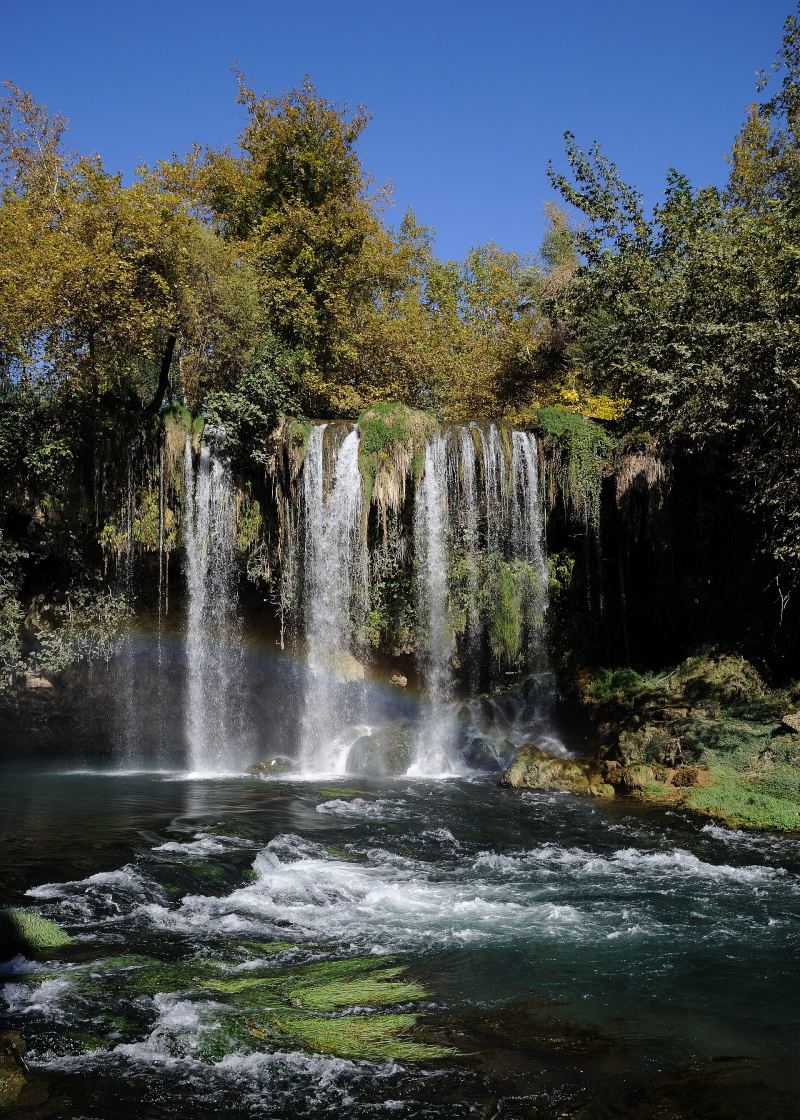 Der Obere Düden-Wasserfall stürzt zwischen Bäumen in ein grünes Becken